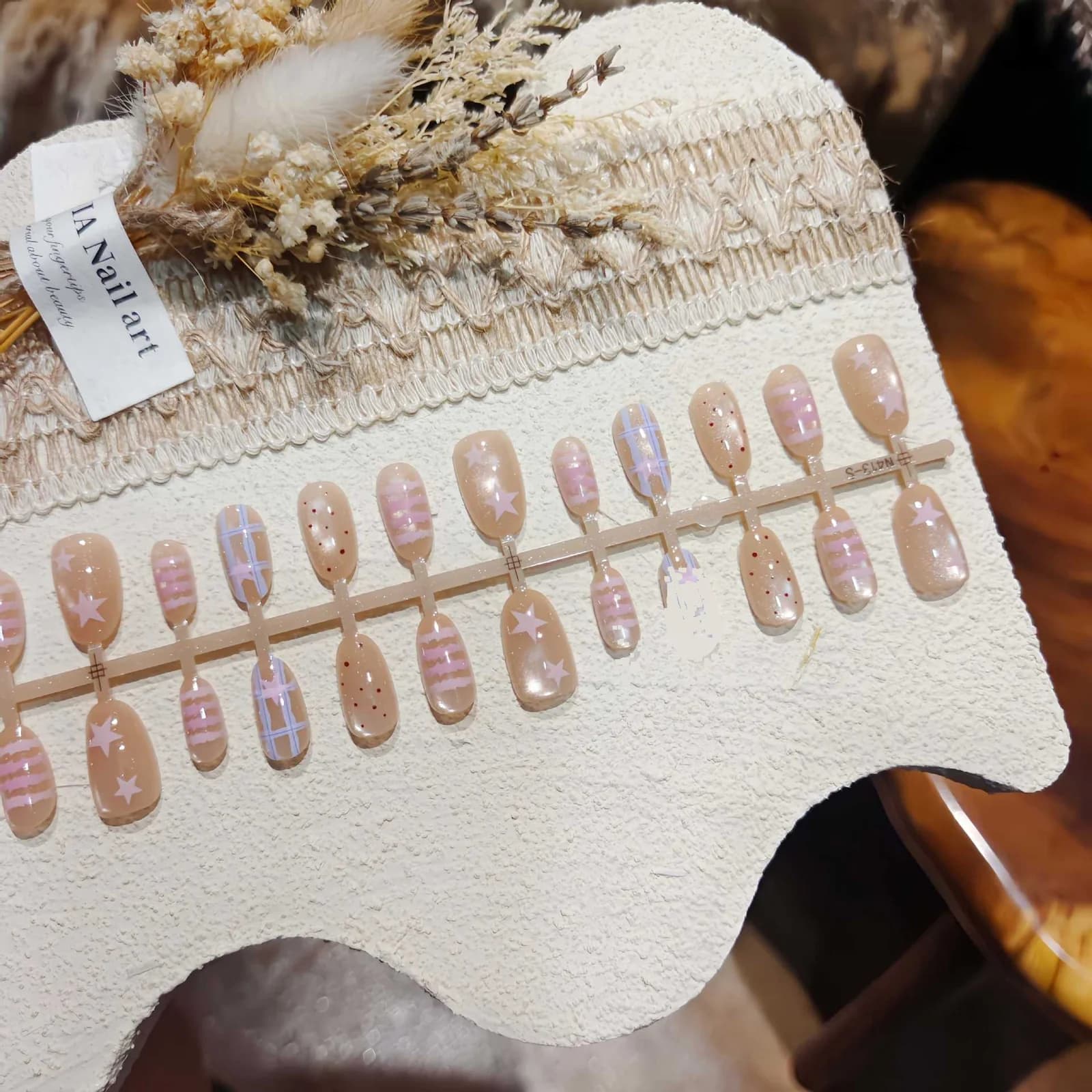 Korta ovala lösnaglar med stjärnor och prickmönster