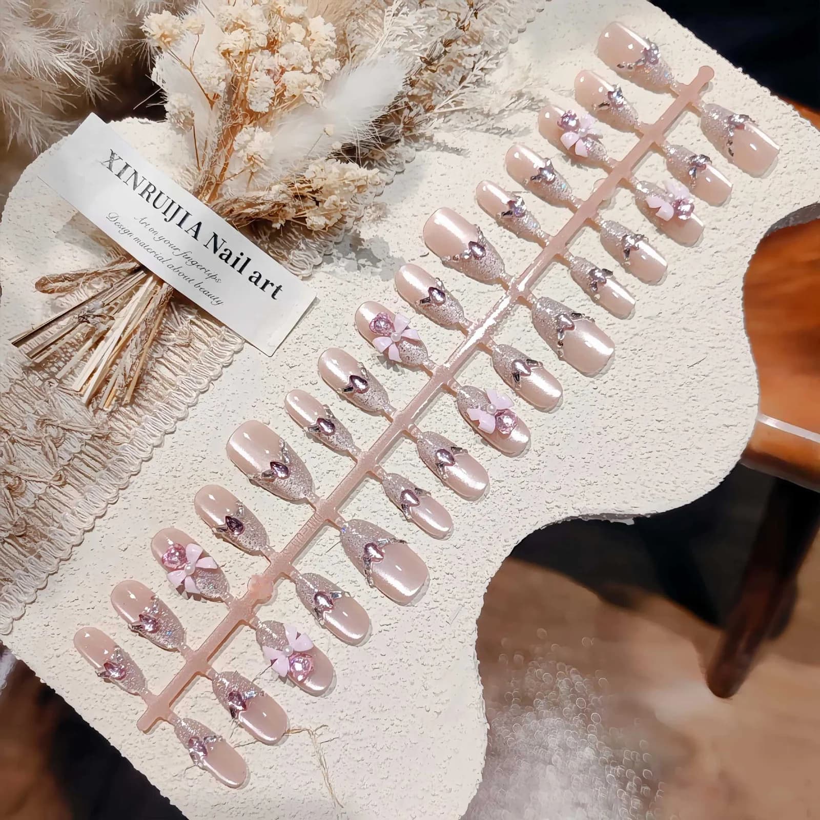 Rosa tryck-på-naglar med kattöga, glitter och rosett